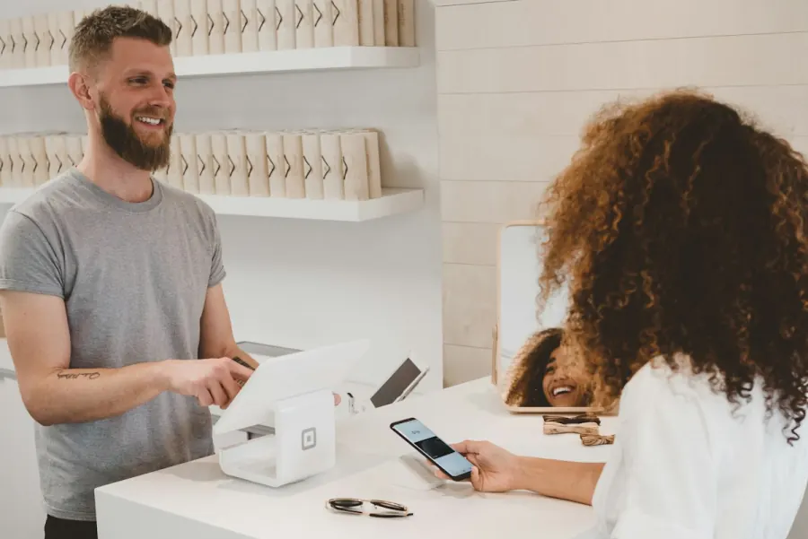 Customer completing a mobile payment at a retail counter